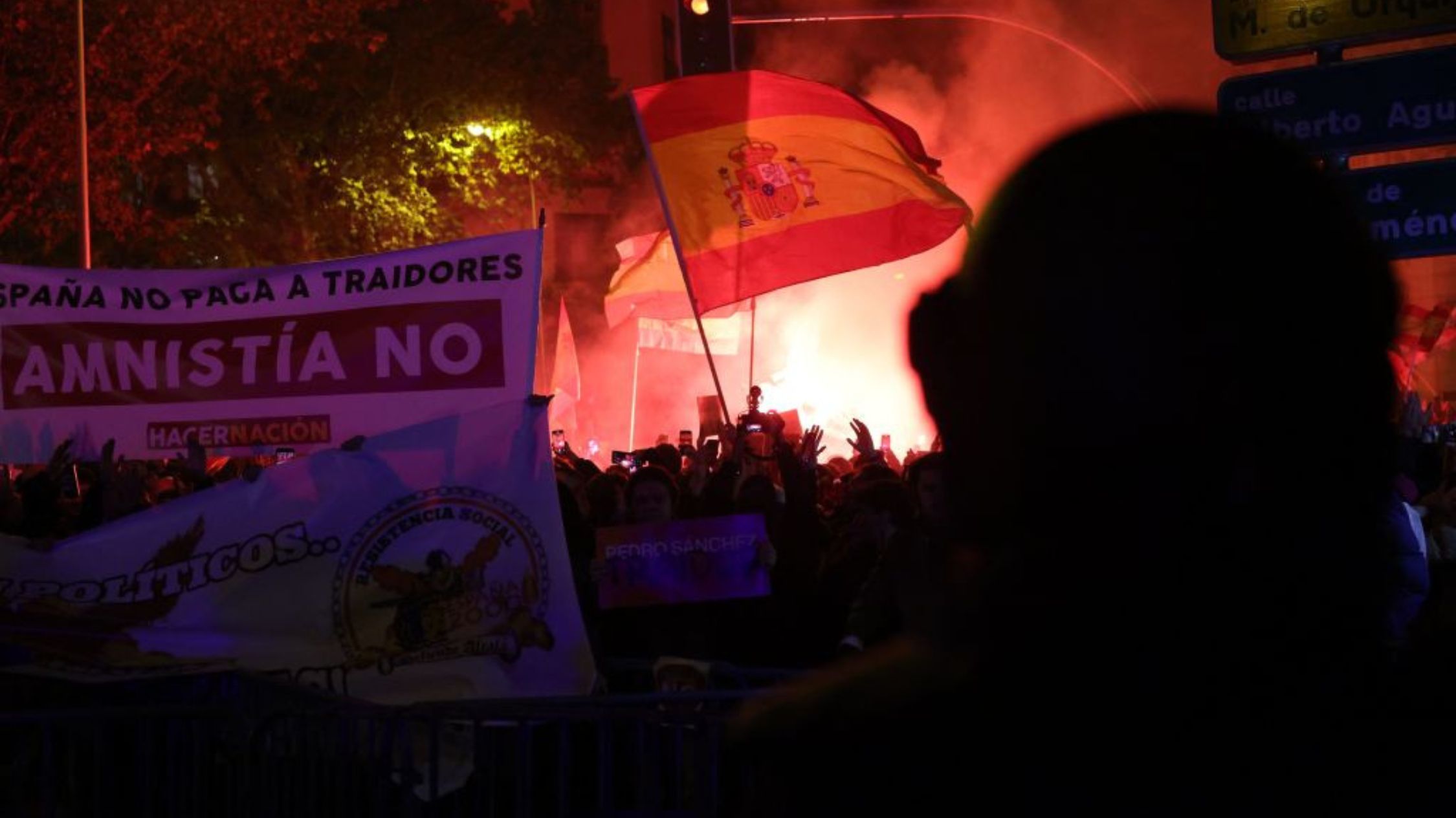 Manifestantes sostienen banderas y pancartas españolas durante una protesta convocada por movimientos de extrema derecha contra las negociaciones gubernamentales para conceder una amnistía a las personas involucradas en el fallido intento de independencia de Cataluña de 2017, cerca de la sede del Partido Socialista Obrero Español (PSOE) en Madrid, el 7 de noviembre de 2023. (Crédito: de PIERRE-PHILIPPE MARCOU/AFP vía Getty Images)