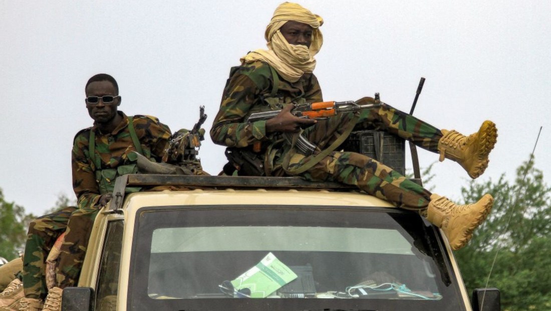 Combatientes viajan en un vehículo que se mueve en un convoy militar que acompaña al gobernador del estado de Darfur en Sudán durante una escala en la ciudad oriental de Gedaref, mientras se dirige a Port Sudan el 30 de agosto de 2023. (Crédito: -/AFP vía Getty Images)