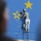 Gente cerca de un mural pintado por el artista británico de graffiti Banksy, que muestra a un trabajador cortando una de las estrellas de una bandera con temática de la Unión Europea, en 2017. (Crédito: Daniel Leal/AFP/Getty Images)