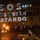 Las palabras "SOS nos están matando" se proyectan en Palacio Nacional mientras una mujer actúa con fuego durante una vigilia con familiares de víctimas de feminicidio y desapariciones forzadas en la Ciudad de México, el 28 de marzo de 2021. (Crédito: PEDRO PARDO/AFP vía Getty Images)