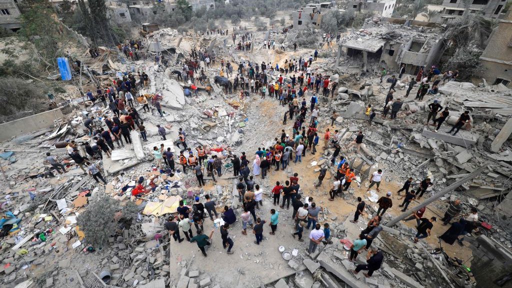 Rescatistas y civiles entre los escombros de un edificio destruido tras un bombardeo israelí en Khan Yunis, en el sur de Gaza, el 12 de noviembre de 2023 (Foto de Mahmud Hams/AFP/Getty Images)