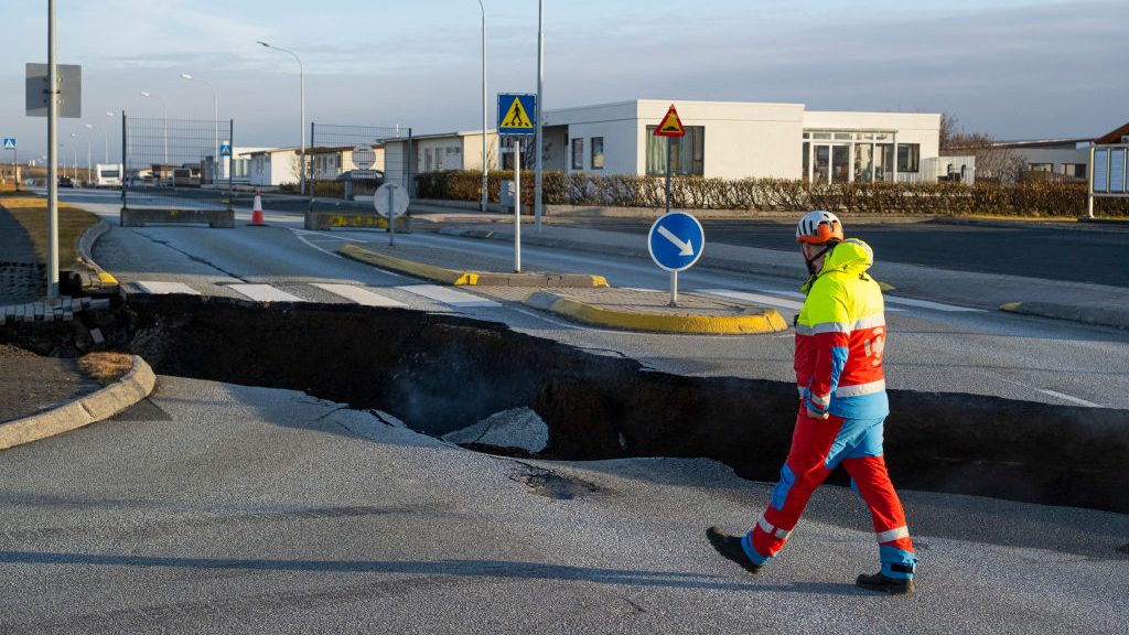 Un trabajador de emergencias cerca de la fisura en el aslfalto enGrindavik, el 13 de noviembre de 2023. (Crédito: KJARTAN TORBJOERNSSON/AFP via Getty Images)