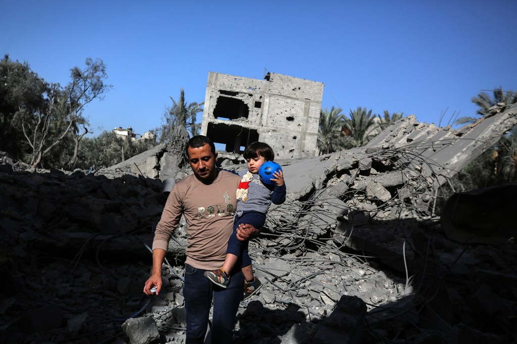Palestinos caminan entre los escombros de un edificio destruido tras un ataque israelí en Deir Al Balah, Gaza, el 23 de noviembre. (Crédito: Majdi Fathi/NurPhoto/Getty Images)