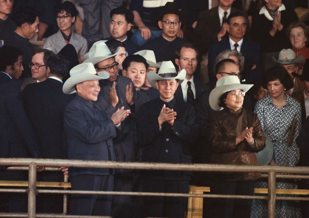 El difunto líder supremo de China, Deng Xiaoping (izquierda), con un sombrero de vaquero, aplaude en un rodeo de Houston durante una visita a los Estados Unidos en 1979. (Wally McNamee/Corbis/Getty Images)