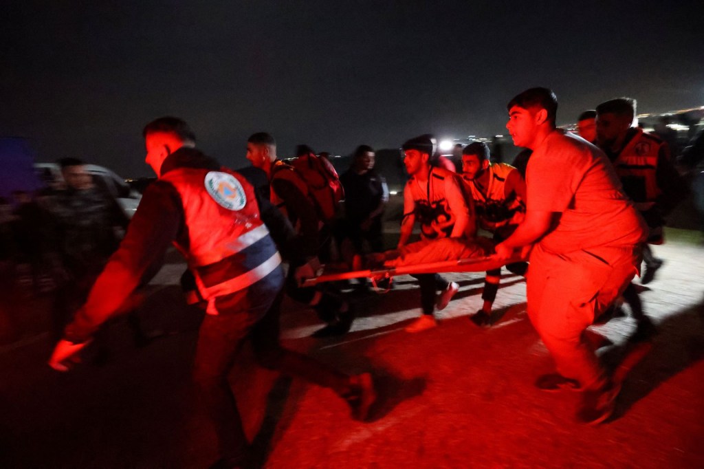 Los médicos transportan a un palestino herido durante enfrentamientos con las fuerzas de seguridad israelíes frente a las instalaciones militares israelíes de Ofer en Baytunia, en la ocupada Ribera Occidental, mientras los palestinos esperan la liberación de prisioneros a cambio de rehenes israelíes retenidos por Hamas el 25 de noviembre de 2023. (Foto de JAAFAR ASHTIYEH/AFP vía Getty Images)
