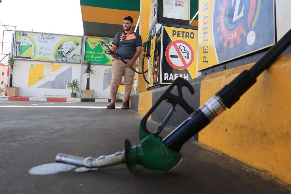 Un empleado de una gasolinera palestina se encuentra junto a los surtidores vacíos de gasolina en Rafah, en el sur de Gaza. (SAID KHATIB/AFP via Getty Images)