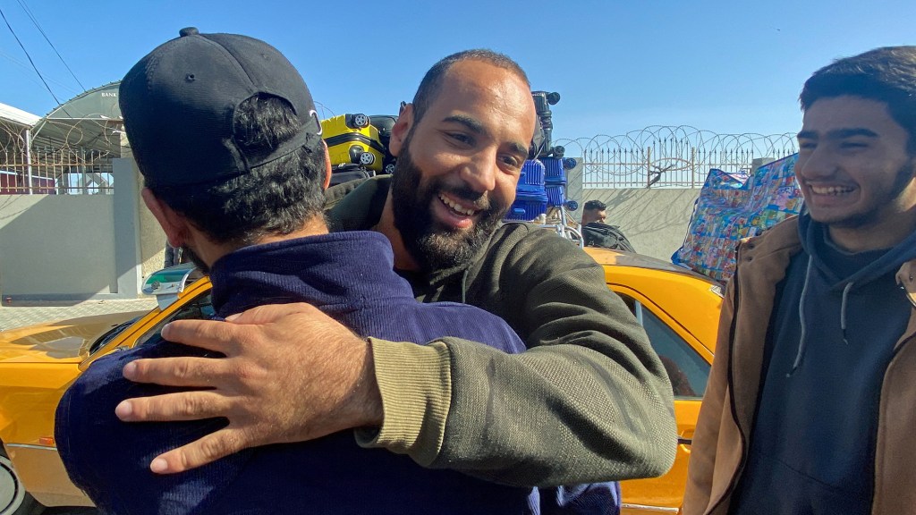 Un palestino que quedó varado en Egipto debido al conflicto entre Israel y Hamas es recibido a su llegada, durante una tregua temporal, al cruce fronterizo de Rafah, en el sur de Gaza, el 24 de noviembre. (Arafat Barbakh/Reuters)