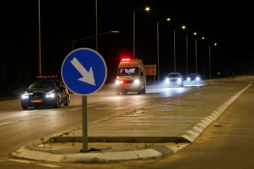 Una ambulancia que se cree que transportaba rehenes liberados se dirige cerca de la frontera entre Israel y Gaza la madrugada del domingo, hora local. (Amir Cohen/Reuters)