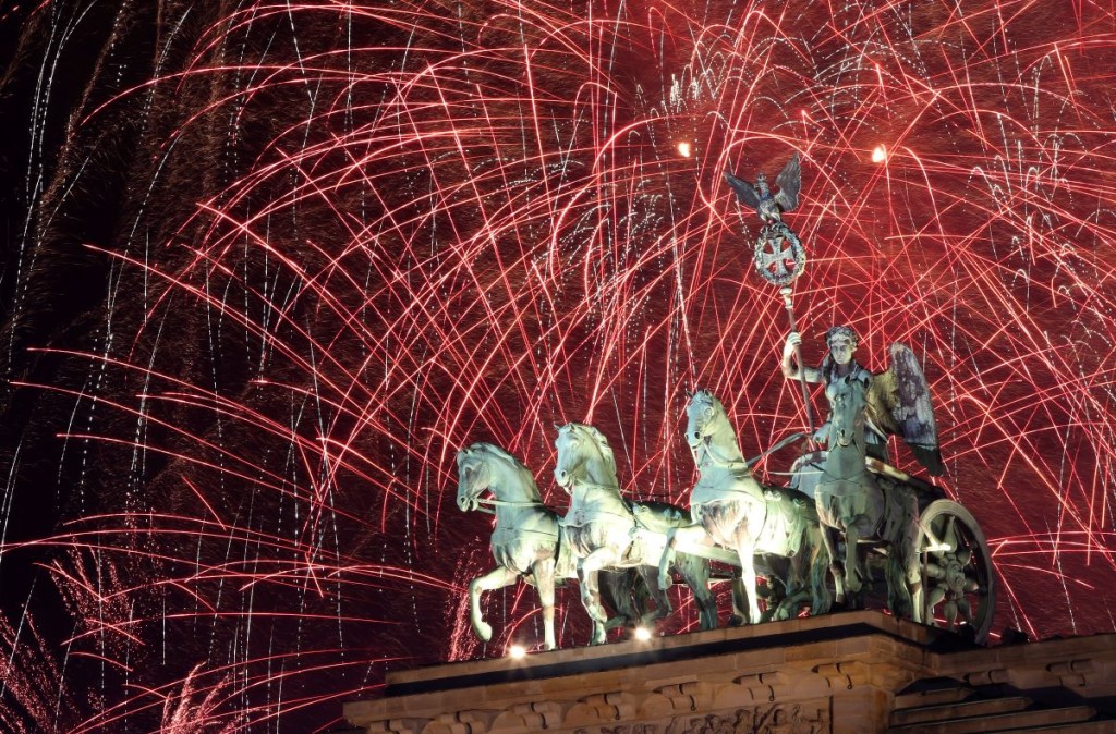 Los fuegos artificiales explotan sobre la Puerta de Brandenburgo a la medianoche del día de Año Nuevo, el 1 de enero de 2024 en Berlín, Alemania. (Foto de Adam Berry/Getty Images)