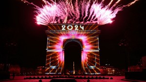 Los fuegos artificiales explotan junto al Arco de Triunfo con "2024" proyectado, en la Avenue des Champs-Elysees durante las celebraciones del Año Nuevo en París, a primera hora del 1 de enero de 2024. (Foto de BERTRAND GUAY /AFP vía Getty Images)