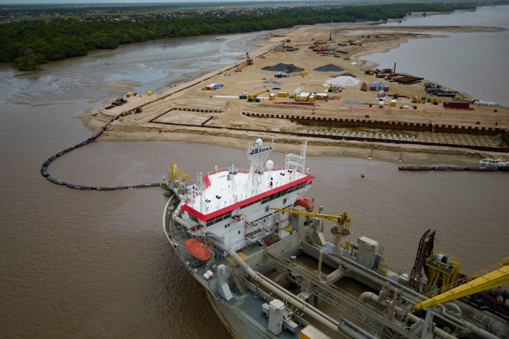A ship creates an artificial island by extracting sea sand to create a coastal port for offshore oil production at the mouth of the Demerara River in Georgetown, Guyana on April 11, 2023.  the world  (Credit: Matias Delacroix/AP)