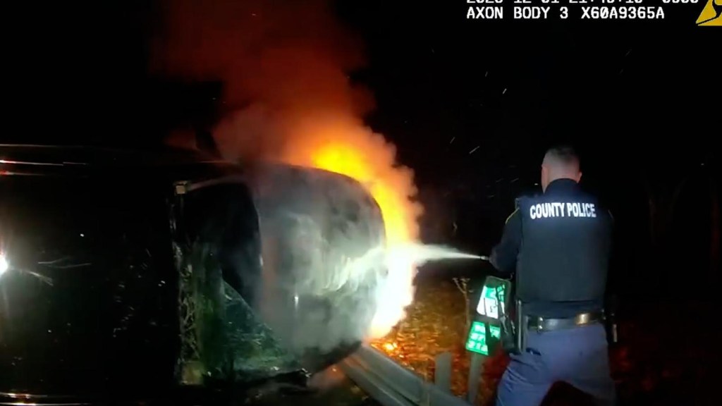 Policías sacan a un sospechoso de un automóvil en llamas