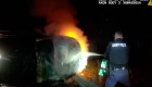 Policías sacan a un sospechoso de un automóvil en llamas