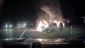 Un policía rescata a una mujer de una camioneta en llamas