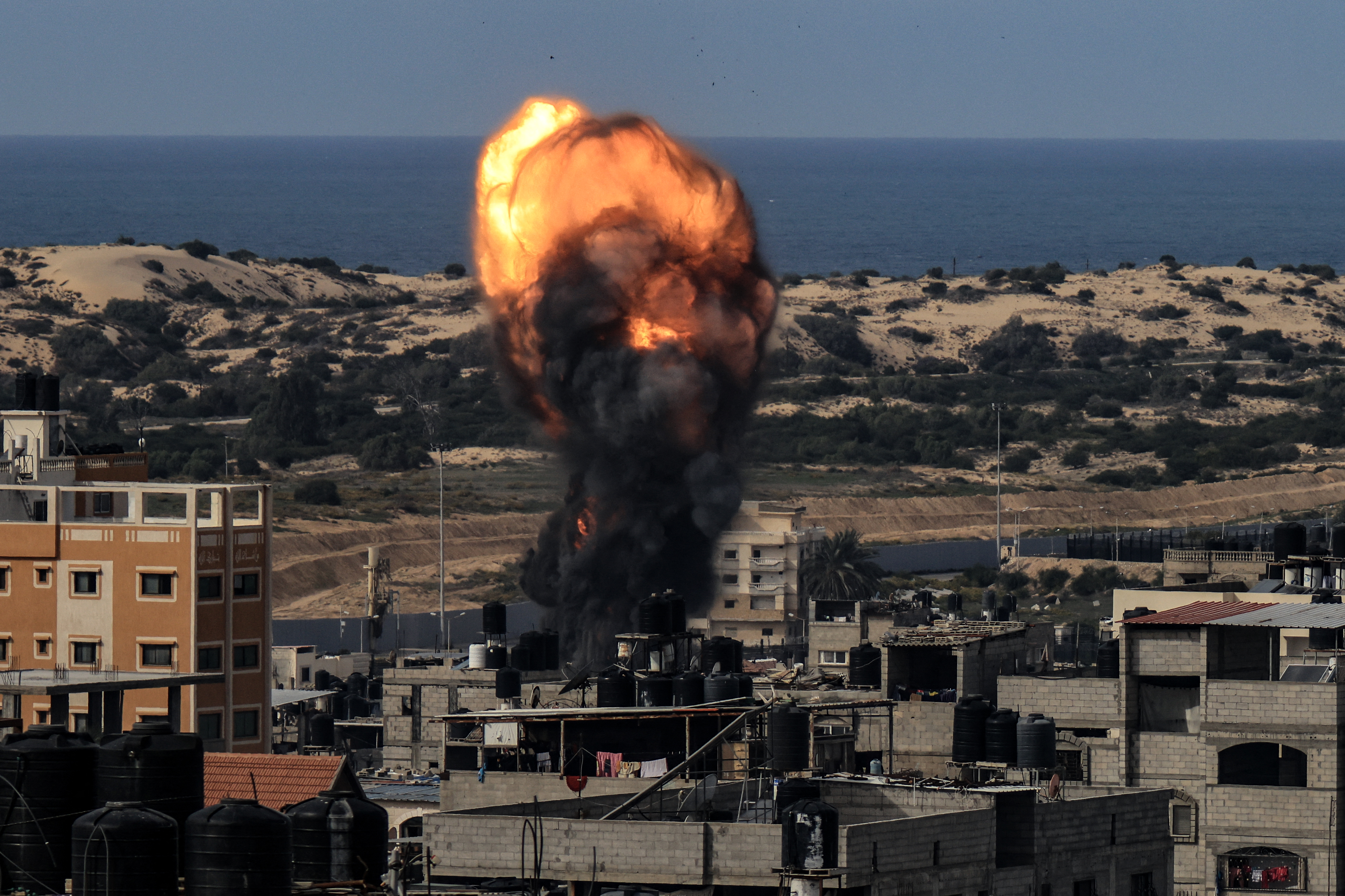 Una bola de fuego se eleva sobre un edificio tras un ataque israelí en Rafah, al sur de Gaza, el 9 de diciembre de 2023 (Crédito: MAHMUD HAMS/AFP via Getty Images)