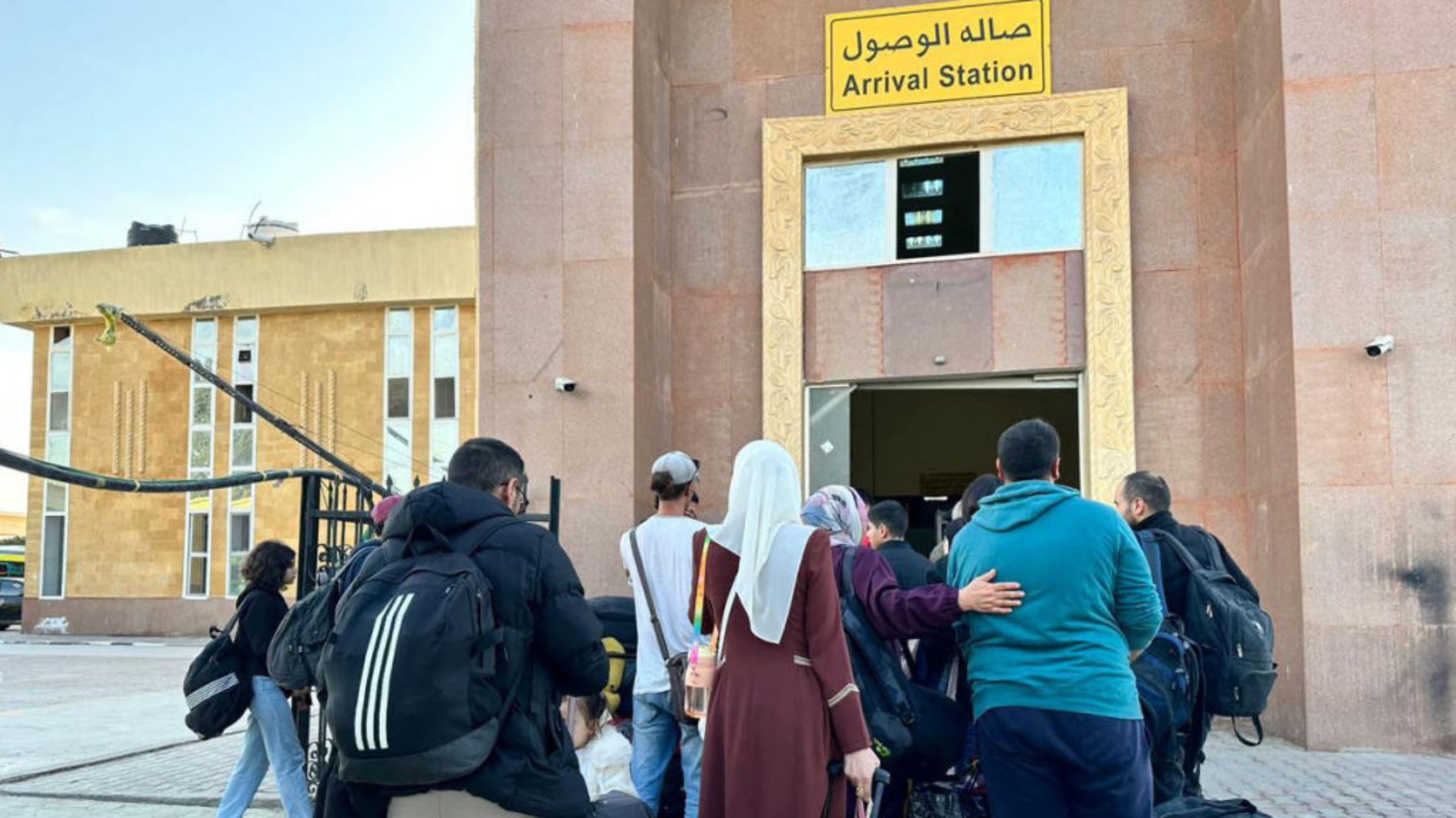 Personas que huyen de Gaza esperan en la parte egipcia del paso fronterizo de Rafah el 3 de diciembre de 2023, en medio de los continuos combates entre Israel y el grupo militante Hamas. (Crédito: STR/AFP vía Getty Images)