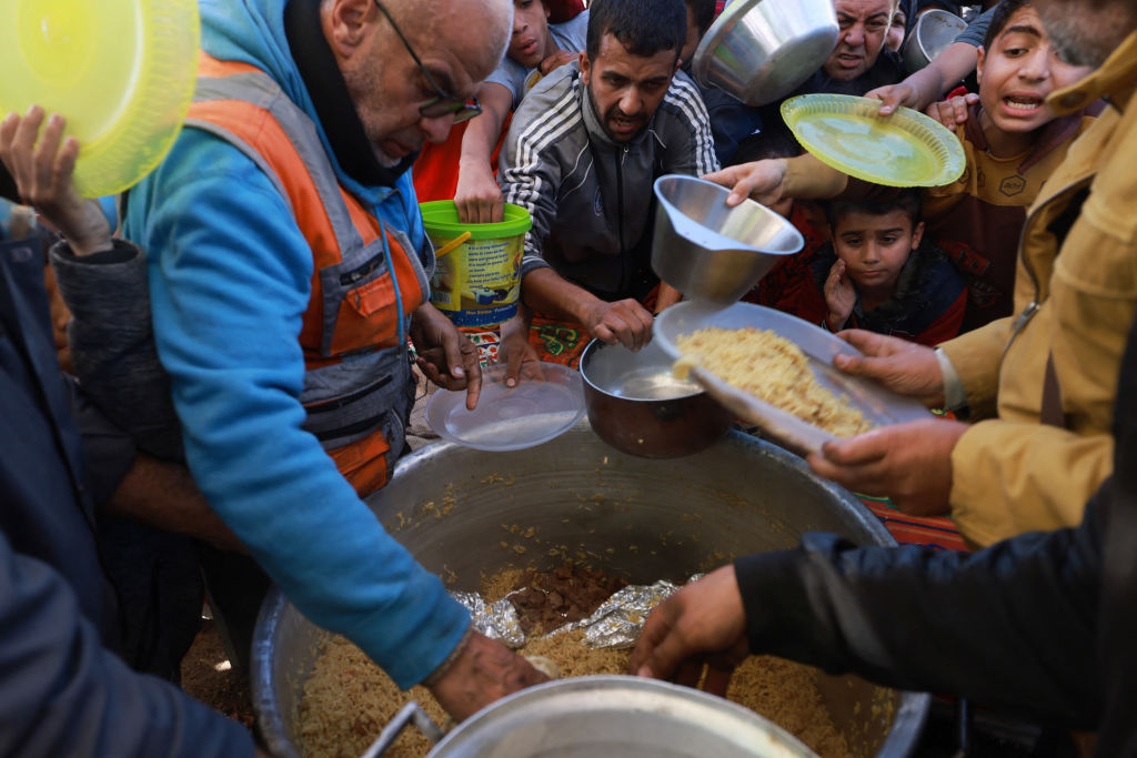 Pengungsi Palestina berbaris untuk menerima sumbangan makanan di kota Rafah di Gaza selatan pada 30 November 2023. (Foto: Muhammad Abed/AFP via Getty Images) 