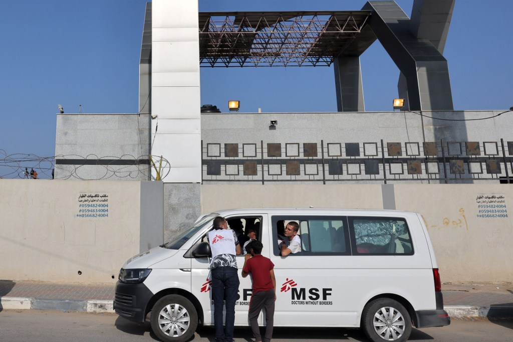 Varias personas esperan en el interior de un vehículo de Médicos Sin Fronteras (MSF) frente a la puerta del paso fronterizo de Rafah con Egipto, en el sur de Gaza, el 1 de noviembre de 2023. (Crédito: Mohammed Abed/AFP/Getty Images)