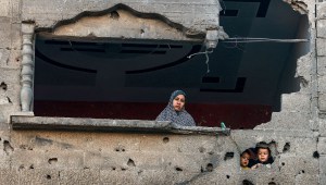 Una mujer palestina y sus niños observan el bombardeo israelí en Rafah, en el sur de la Ciudad de Gaza, el 15 de diciembre de 2023, en medio de continuas batallas entre Israel y Hamas. (Foto de MOHAMMED ABED/AFP vía Getty Images)