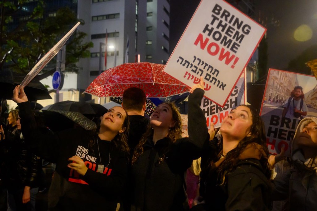 Las familias de los rehenes y sus partidarios piden la liberación de todos los rehenes durante una protesta bajo una intensa lluvia frente al cuartel general de las Fuerzas de Defensa de Israel el 23 de diciembre de 2023 en Tel Aviv, Israel. (Alexi J. Rosenfeld/Getty Images)