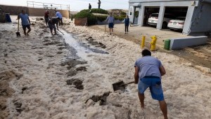 Los vecinos de Pierpont, California, remueve escombros en Bath Lane para ayudar a drenar el agua después de que el fuerte oleaje rompiera un malecón y una berma de arena el 28 de diciembre. (Brian van der Brug/Los Angeles Times/Getty Images)