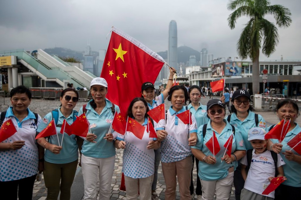 Un grupo de personas ondea banderas chinas para conmemorar el Día Nacional de China en Hong Kong el 1 de octubre de 2023. (Crédito: Vernon Yuen/NurPhoto/Getty Images)