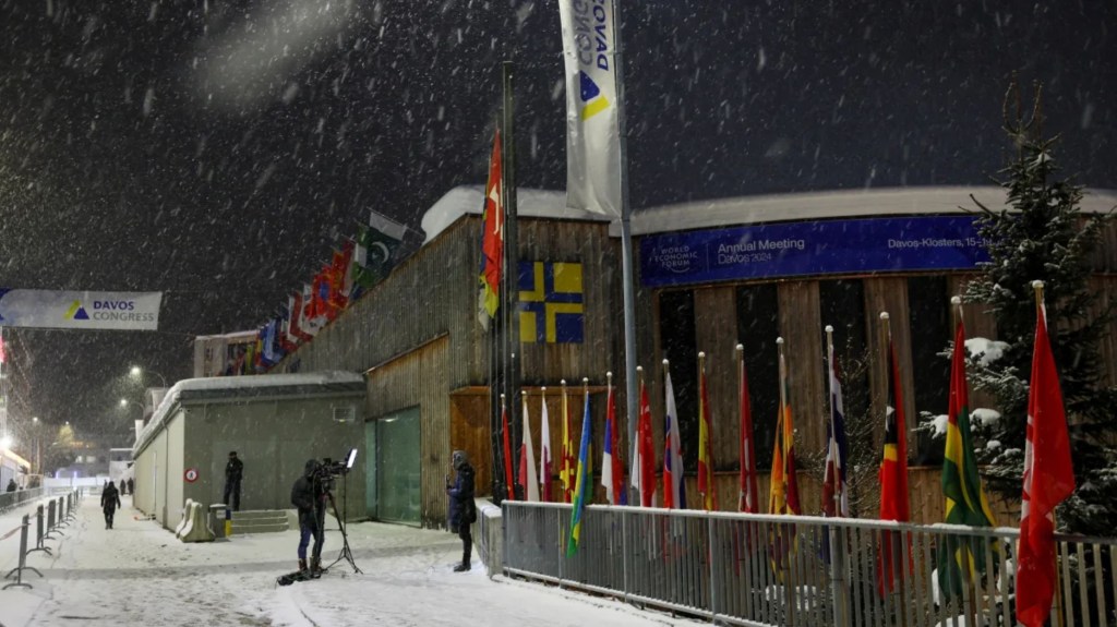 Miembros de los medios de comunicación se encuentran afuera de la sede del Foro Económico Mundial durante una nevada, en el primer día de la reunión anual de 2024 en Davos, Suiza. (Crédito: Denis Balibouse/Reuters)