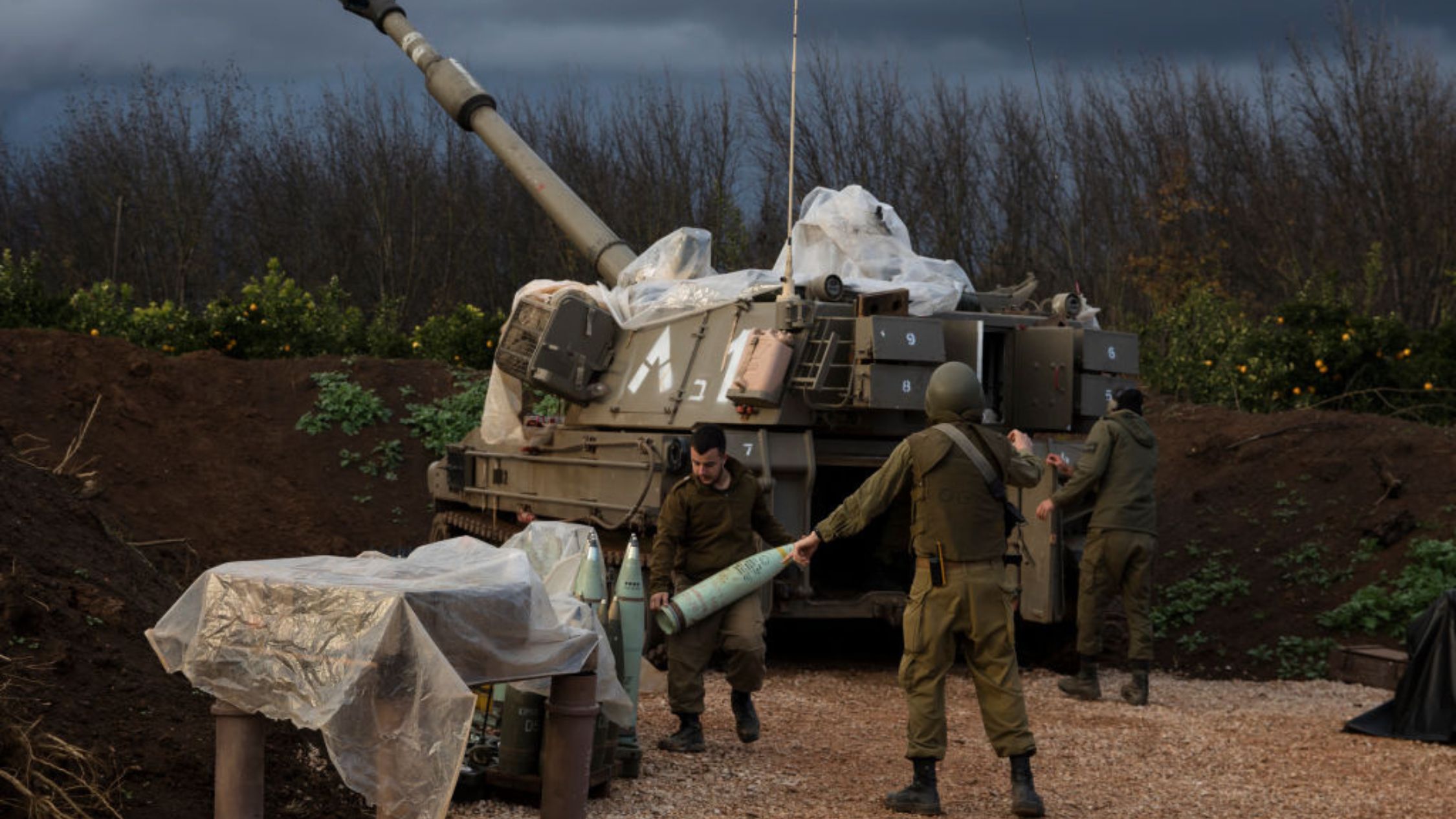 Un soldado israelí lleva un proyectil explosivo a una unidad de artillería cerca de la frontera con el Líbano, el 11 de enero de 2024, en el norte de Israel. (Crédito: Amir Levy/Getty Images)