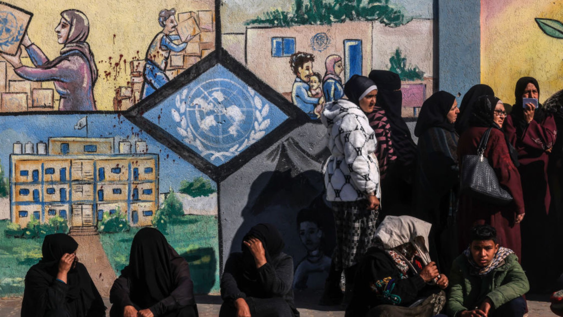 Palestinos desplazados hacen fila para recibir ayuda frente al centro del UNRWA en Rafah, en el sur de Gaza, el 28 de enero de 2024. (Crédito: AFP vía Getty Images)