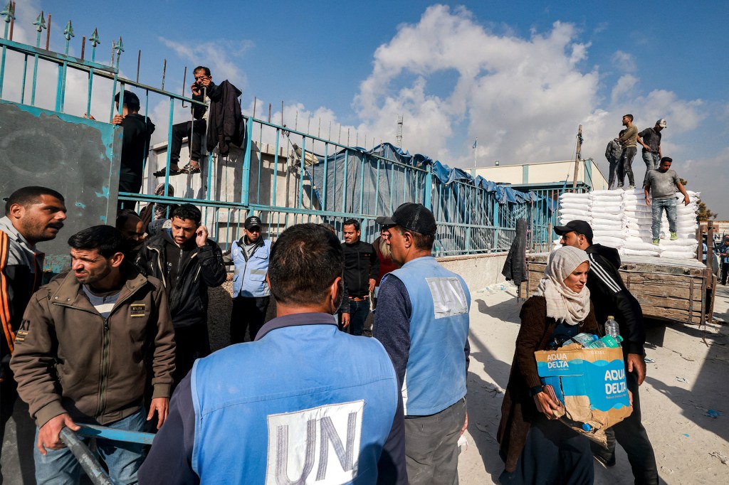 Trabajadores de la Agencia de Obras Públicas y Socorro de las Naciones Unidas para los Refugiados de Palestina reparten suministros en Rafah, Gaza, el 12 de diciembre. (Mohammed Abed/AFP/Getty Images)