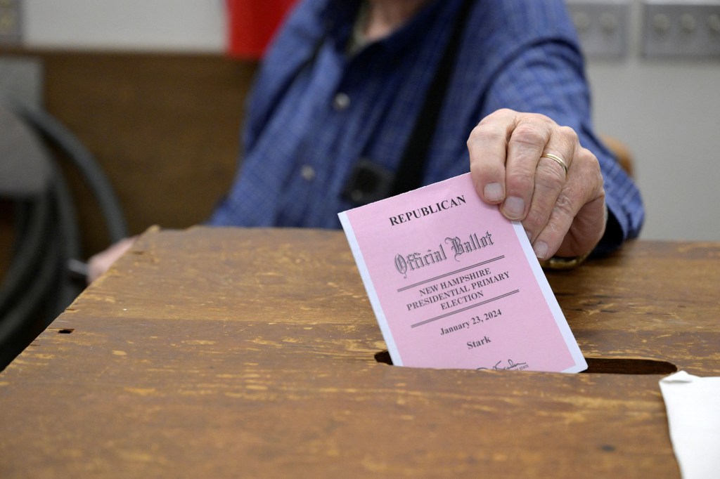 Bill Joyce, moderador de Stark, ingresa una boleta en la urna durante la primera elección primaria presidencial en el país en el Departamento de Bomberos Voluntarios de Stark en Stark, Nueva Hampshire, el martes. (Fe Ninivaggi/Reuters)