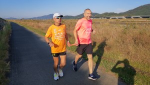 Leung trota junto a un guía durante su reciente carrera de larga distancia en Japón. (The Roly-Poly Inclusion Movement Association)