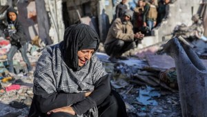Una mujer sentada entre casas dañadas por los ataques aéreos israelíes, el 18 de enero de 2024 en Rafah, Gaza. (Ahmad Hasaballah/Getty Images)