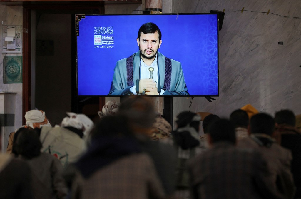 Los combatientes hutíes recién reclutados ven una conferencia grabada sobre Israel y los judíos impartida por el máximo líder del movimiento hutí, Abdul-Malik al-Houthi, durante una ceremonia al final de su entrenamiento en Sanaa, Yemen, el 11 de enero. (Khaled Abdullah/Reuters)