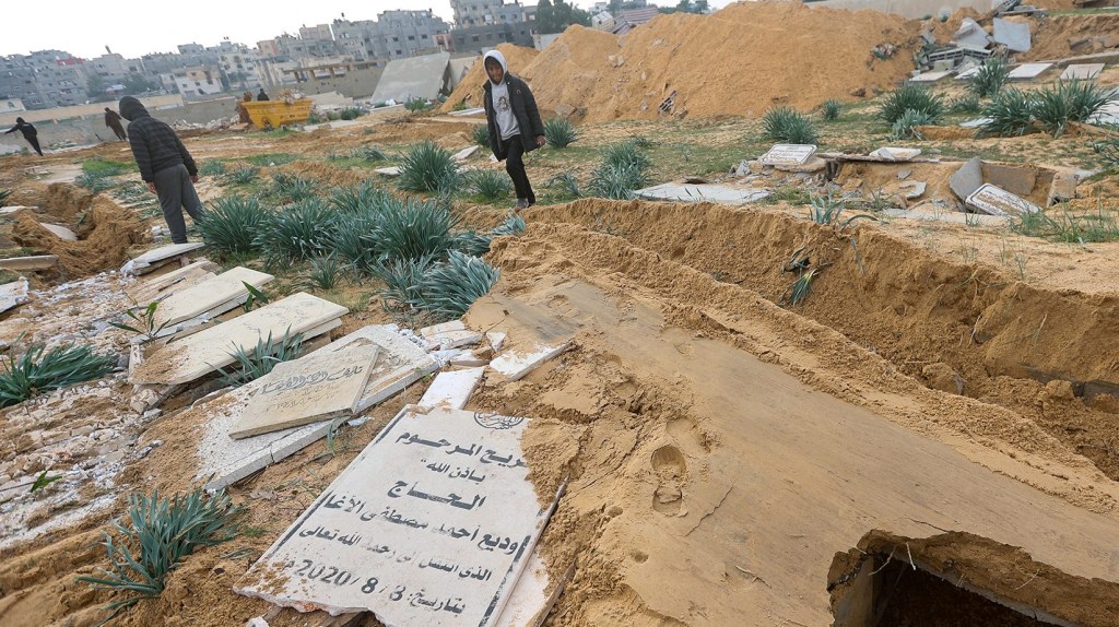 Palestinos revisan tumbas dañadas en un cementerio tras una incursión israelí en Khan Younis, Gaza, el 17 de enero. (Foto: Ahmed Zakot/Reuters).