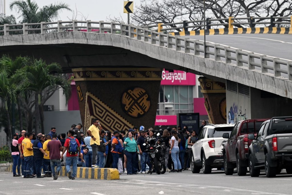 La gente se reúne cerca de las instalaciones del canal de televisión TC de Ecuador después de que hombres armados no identificados irrumpieran en el estudio de televisión estatal en vivo el 9 de enero de 2024, en Guayaquil, Ecuador. (Foto de MARCOS PIN/AFP vía Getty Images)