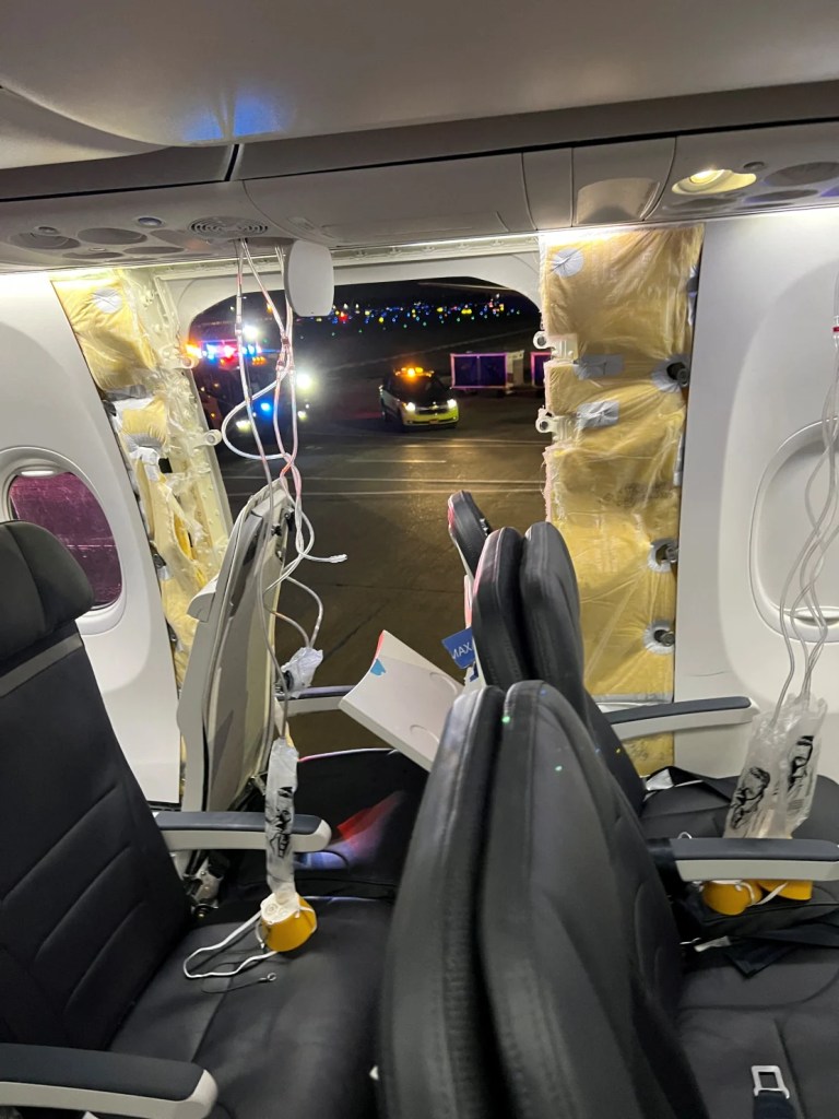Las máscaras de oxígeno de los pasajeros cuelgan del techo junto a una ventana faltante y una parte de una pared lateral de un vuelo 1282 de Alaska Airlines. (@strawberrvy/Instagram via Reuters)