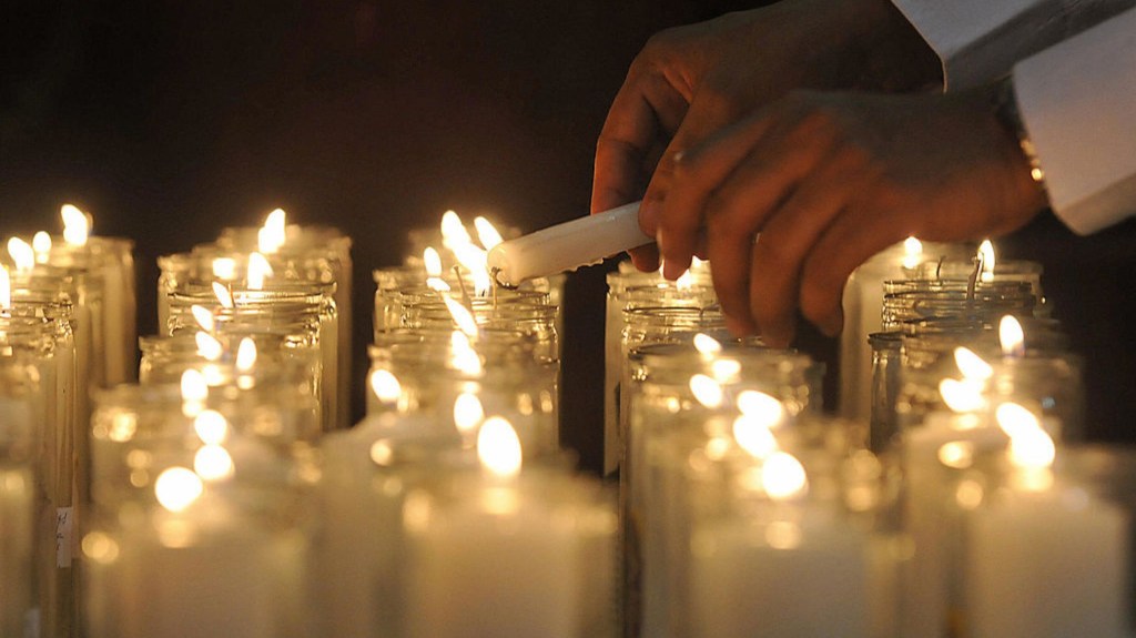 Un hombre coloca una vela frente a una imagen de Jesucristo durante una ceremonia del Jueves Santo en la Catedral del Casco Viejo, en la Ciudad de Panamá, el 20 de marzo de 2008. (Crédito: ELMER MARTINEZ/AFP vía Getty Images)