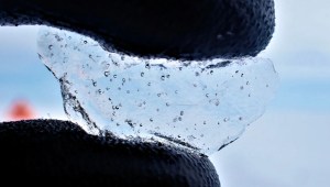 Un científico sostiene un trozo de núcleo de hielo extraído de la Antártida Occidental, mostrando las burbujas de aire atrapadas en su interior. (Crédito: Universidad de Cambridge/British Antarctic Survey)
