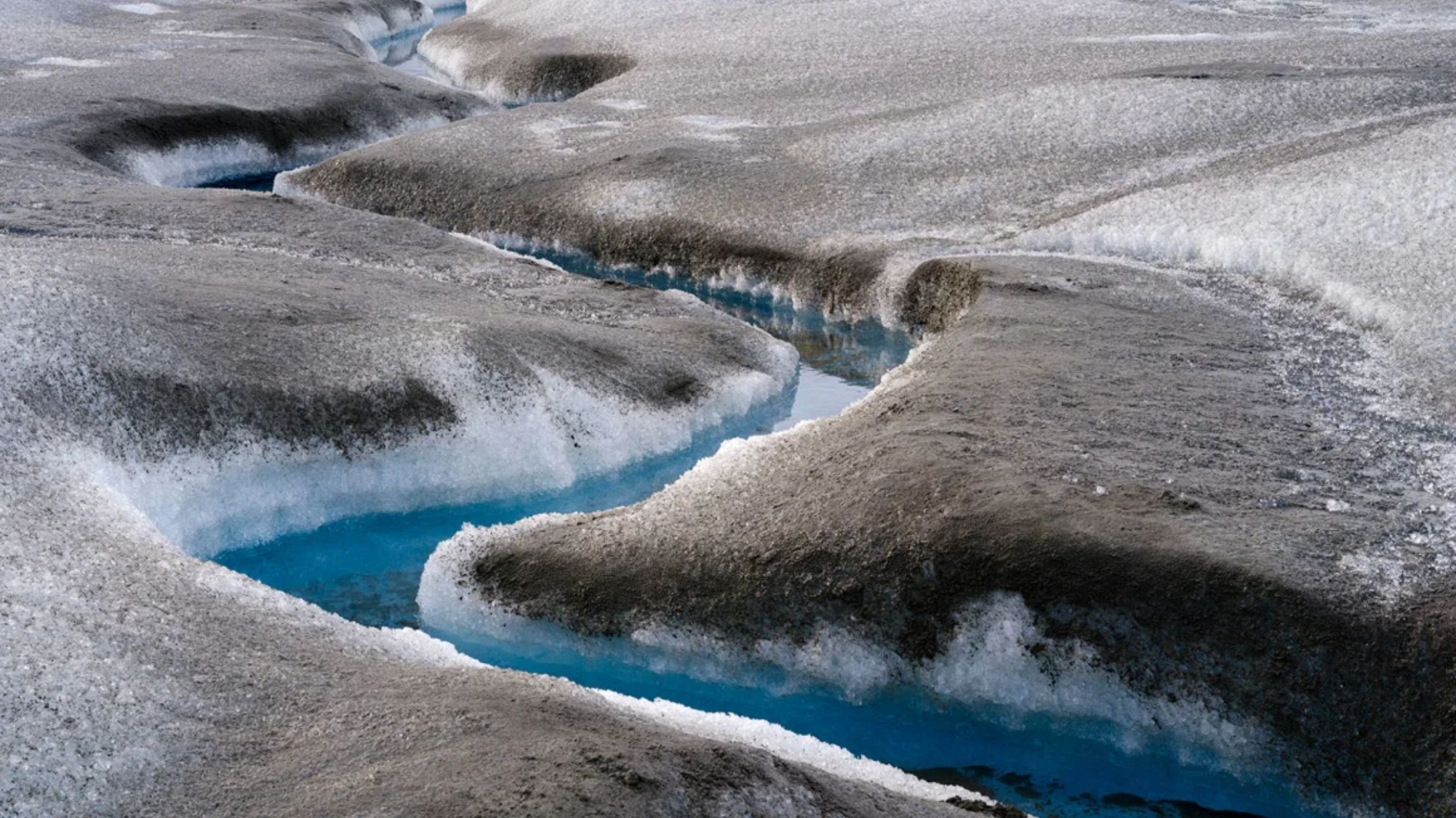 Sedimento marrón sobre hielo derretido cerca de Kangerlussuaq en Groenlandia. El rápido deshielo está teniendo una serie de impactos en el paisaje de Groenlandia, incluida la sedimentación de sus aguas. (Crédito: Martin Zwick/REDA&CO/Universal Images Group/Getty Images)