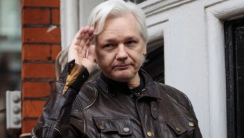 Julian Assange hace un gesto mientras habla con los medios desde el balcón de la Embajada de Ecuador el 19 de mayo de 2017 en Londres. (Crédito: Jack Taylor/Getty Images)