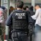 Un agente del ICE monitorea a cientos de solicitantes de asilo que están siendo procesados al ingresar al edificio federal Jacob K. Javits el 6 de junio de 2023 en la ciudad de Nueva York. (Crédito: David Dee Delgado/Getty Images)