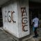 Un niño ingresa a una tienda con graffitis de las Autodefensas Gaitanistas de Colombia (AGC) o Clan del Golfo. (JOAQUIN SARMIENTO/AFP via Getty Images)