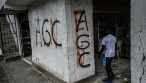 Un niño ingresa a una tienda con graffitis de las Autodefensas Gaitanistas de Colombia (AGC) o Clan del Golfo. (JOAQUIN SARMIENTO/AFP via Getty Images)