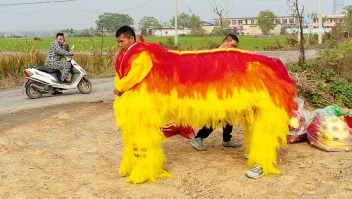 Participantes del festival visten un traje de danza del león para dos personas en Huozhuang, una aldea en la provincia china de Henan. (Zhang Xiao)