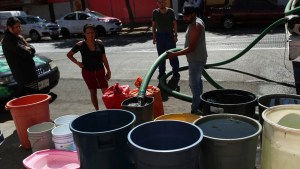 La gente llena baldes de una pipa de agua en el barrio de Azcapotzalco en la Ciudad de México el 26 de enero de 2024. (Foto: Henry Romero/Reuters).