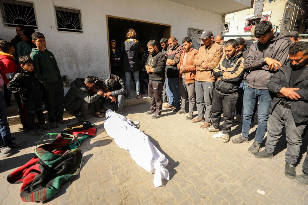 Los palestinos lloran cerca de un cuerpo en el Hospital Kamal Edwan en Beit Lahia, al norte de Gaza, el 29 de febrero, después de que soldados israelíes abrieran fuego mientras la gente esperaba comida y ayuda. (AFP/Getty Images)