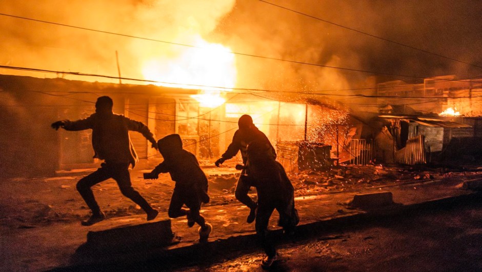 Varias personas corren para ponerse a cubierto tras una serie de explosiones en la zona de Embakasi, en Nairobi, el 2 de febrero de 2024. (Crédito: Luis Tato/AFP/Getty Images)