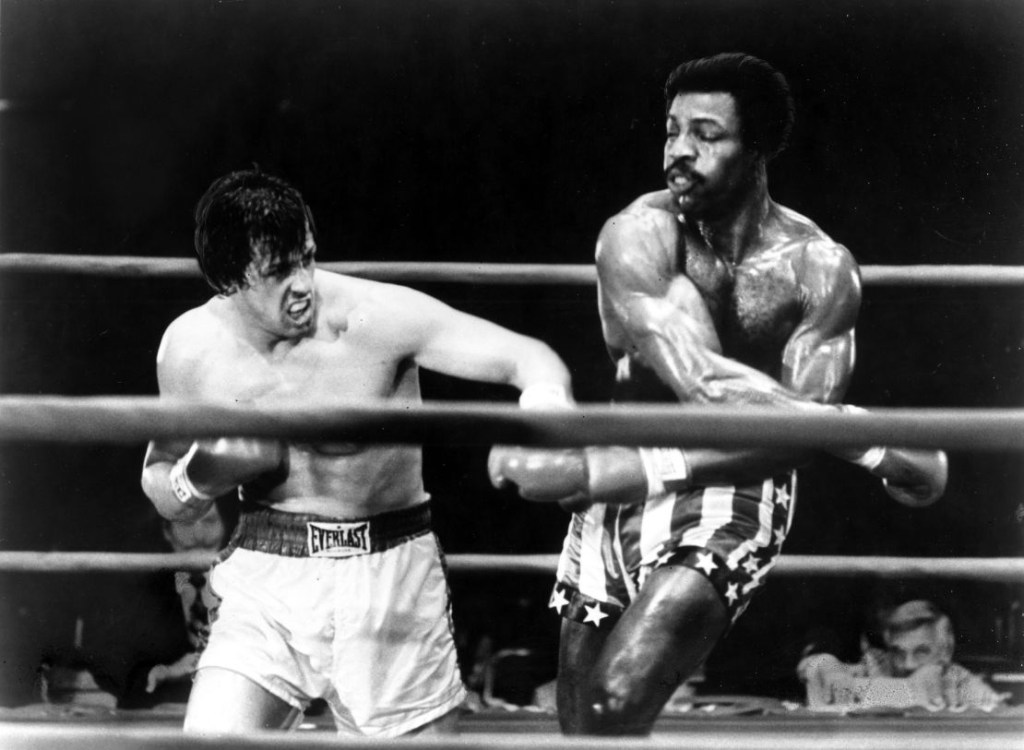 Sylvester Stallone y Carl Weathers interpretan una escena de boxeo en la película "Rocky", dirigida por John G. Avildsen. (Crédito: Archivos Michael Ochs/Getty Images)