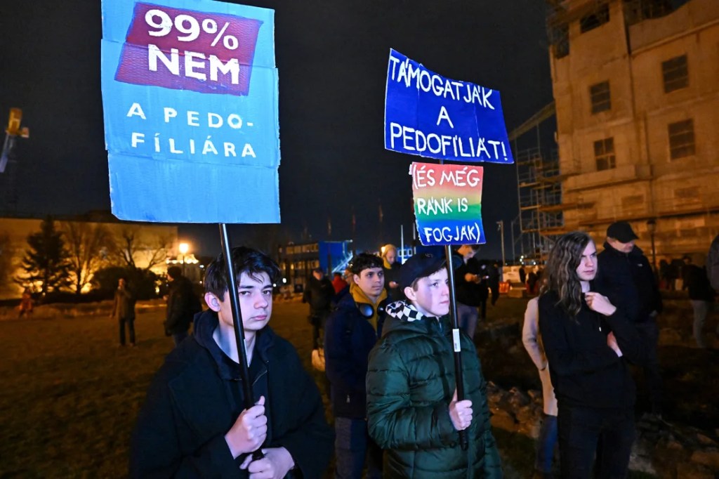 "El 99% dice no a la pedofilia", se lee en un cartel. "Ellos [el gobierno] apoyan la pedofilia (y nos culpan a nosotros)", se lee en otro, durante una protesta en Budapest, el 14 de febrero de 2024. (Foto: Attila Kisbenedek/AFP/Getty Images).